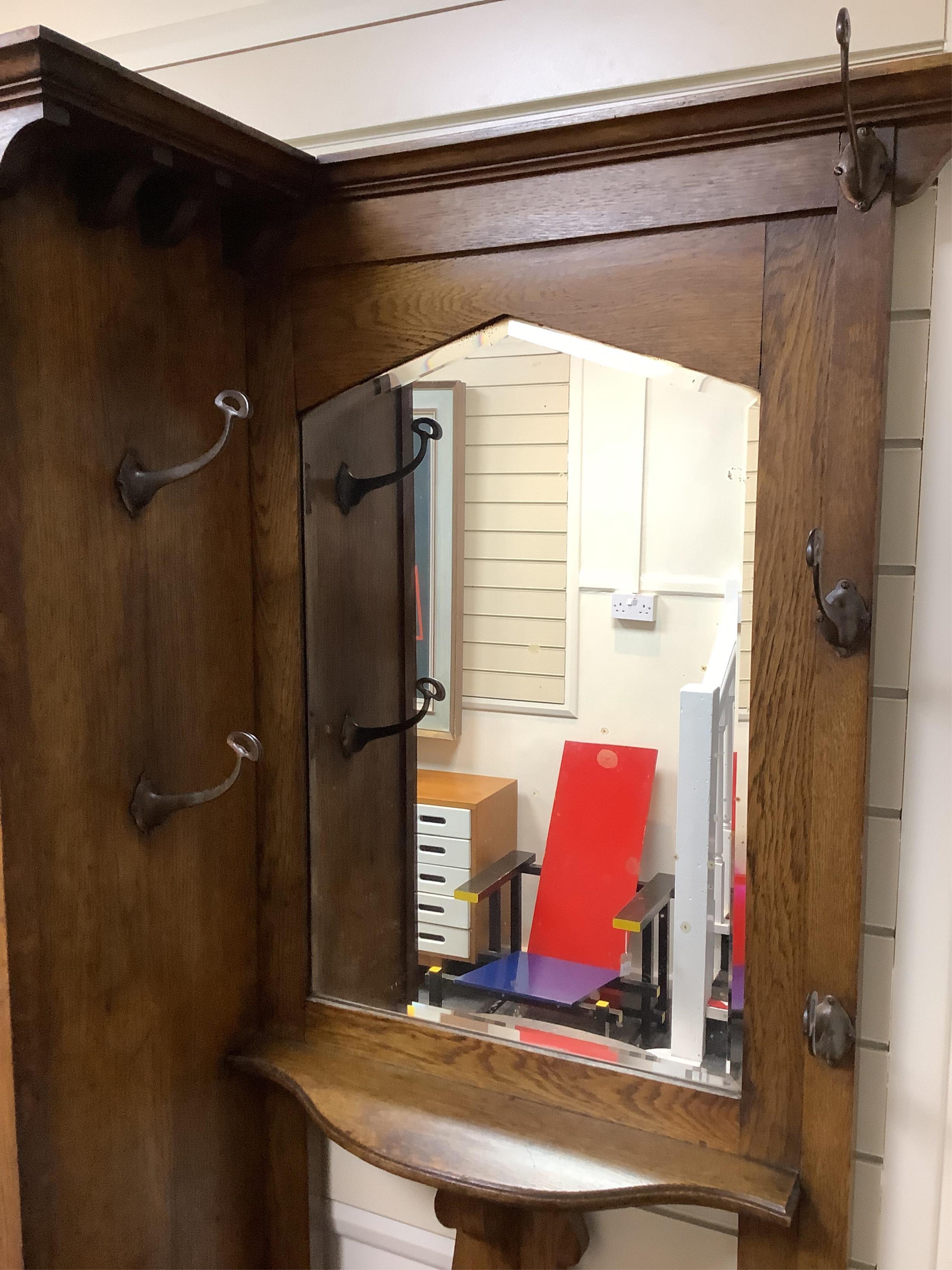 Manner of Liberty & Co: An Arts and Crafts embossed copper mounted oak hall cupboard